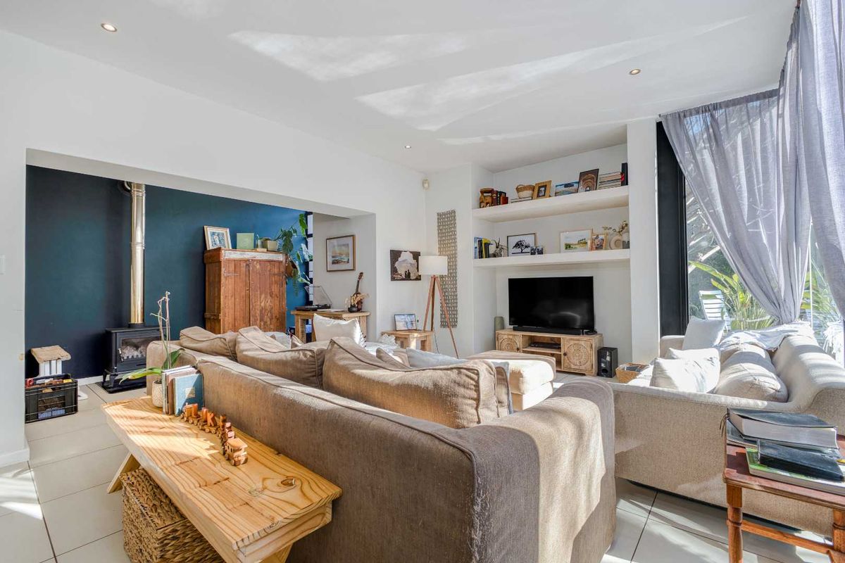 Spacious living room featuring a modern wood-burning fireplace, built-in shelving, and large windows that provide ample natural light.