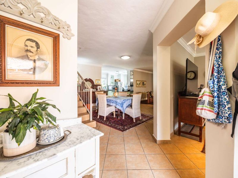 Open plan living and dining area featuring tiled flooring, a staircase, and neutral wall finishes, providing a connected flow between the home's main living spaces.