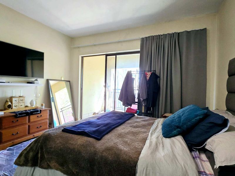 A bedroom featuring tiled flooring and a sliding glass door providing access to an outdoor balcony area.
