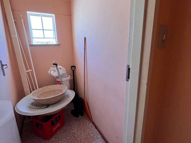 A small utility or storage space featuring tiled flooring and a window, suitable for use as a pantry or laundry area.
