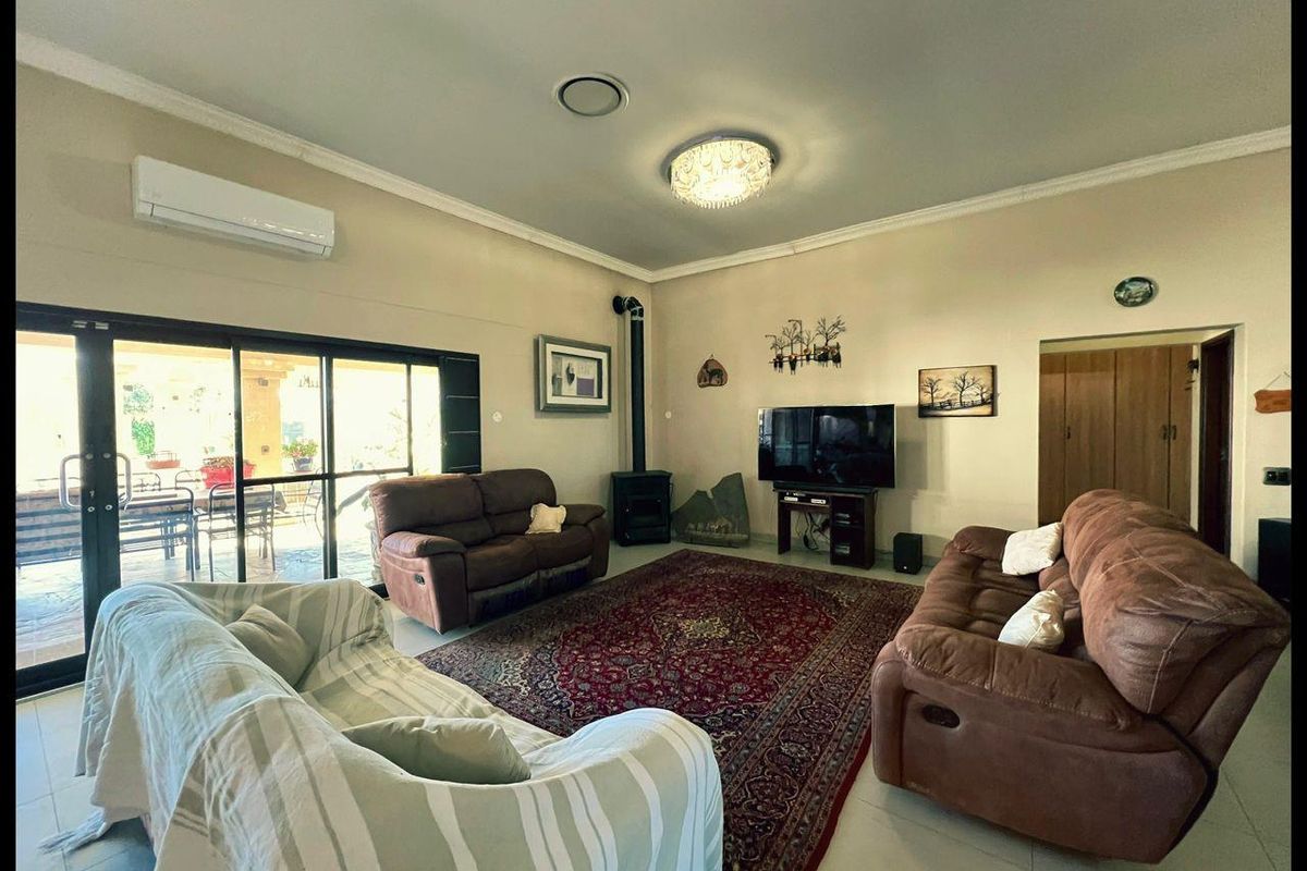 Spacious living room featuring a built-in fireplace, split-system air conditioning, and large sliding glass doors providing access to the outdoor patio area.