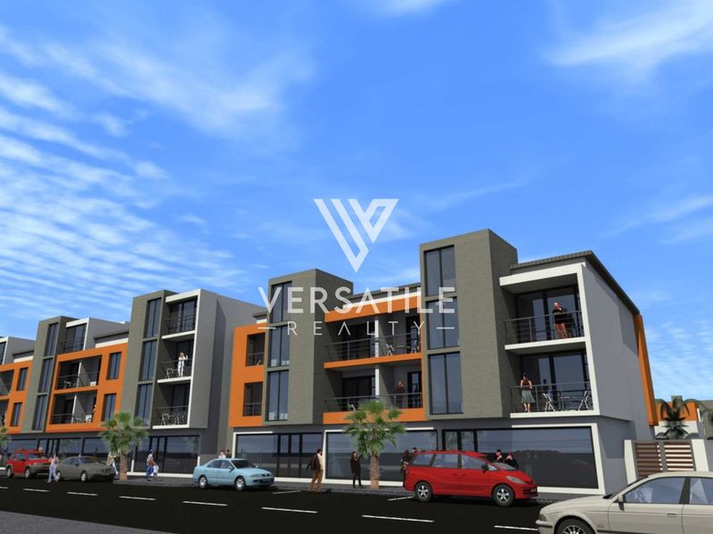 A modern multi-story retail and residential building featuring ground-floor storefronts and upper-level balconies with contemporary architectural finishes.