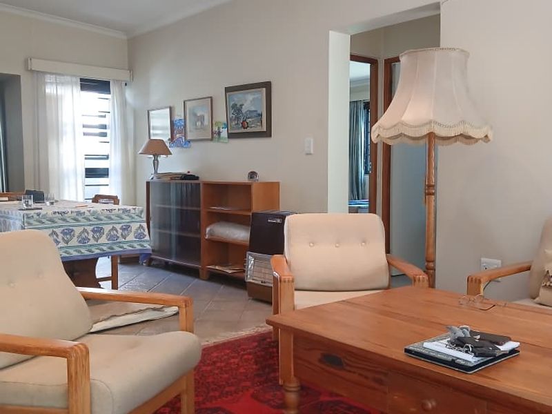 A comfortable living room featuring tiled flooring, recessed downlighting, and coved ceilings, providing a neutral base for potential interior updates.