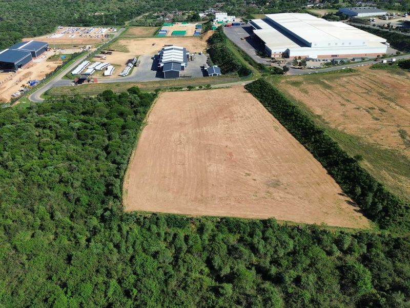 Aerial view of a cleared industrial land parcel situated within a developed industrial park area.