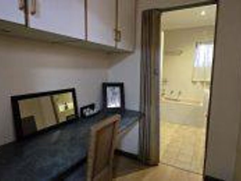 Bedroom featuring built-in cabinetry and a desk area with direct access to an en-suite bathroom.