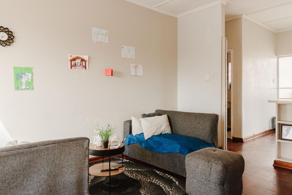 A living room area featuring classic parquet flooring and coved ceiling details, providing a neutral foundation for interior design updates.