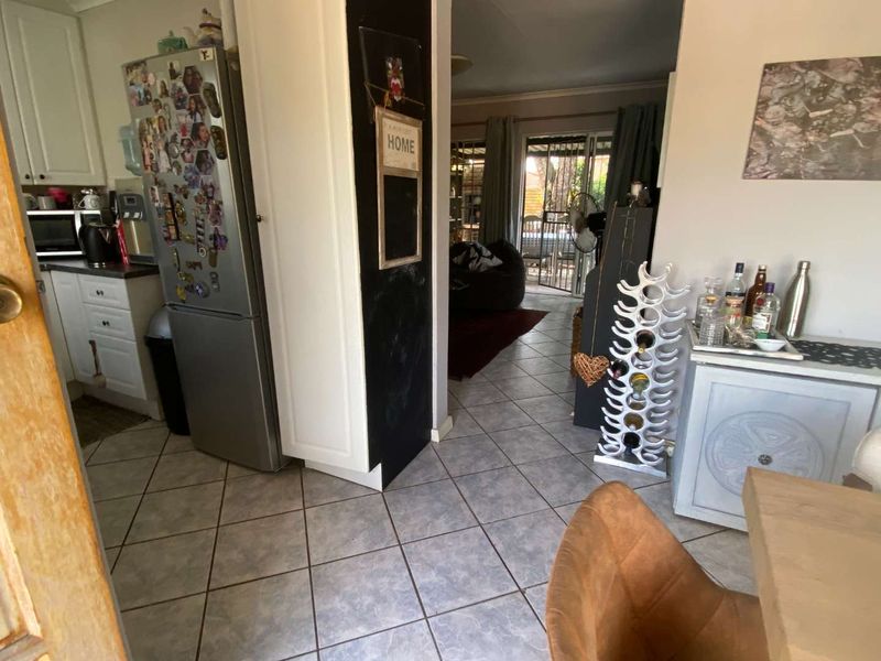 Open plan kitchen and living area featuring tiled flooring and direct access to an outdoor patio through a sliding glass door.