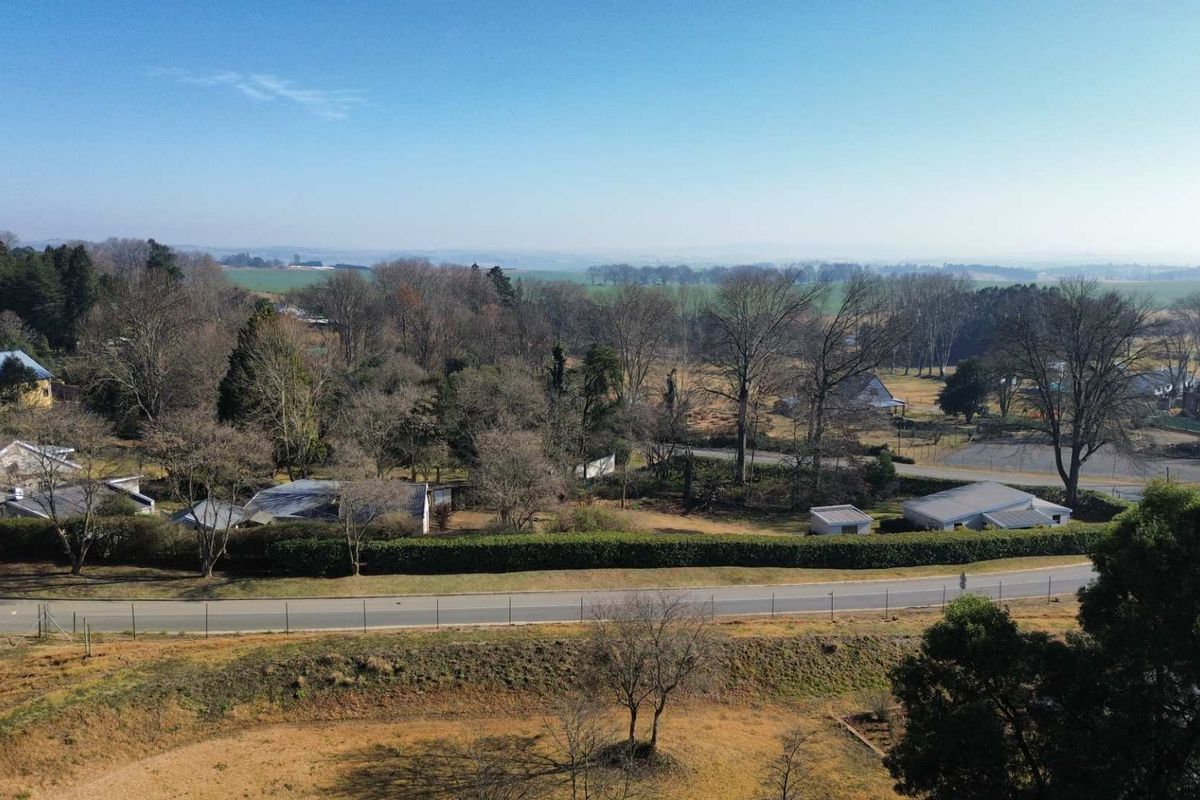 An aerial view of the residential land parcel showing surrounding vegetation, road access, and neighboring properties in a rural setting.