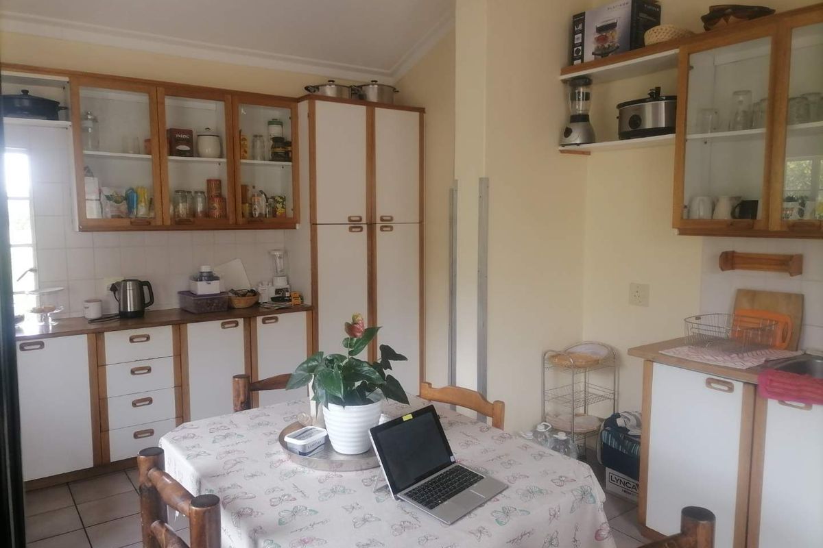 A functional kitchen featuring built-in cabinetry, tiled splashbacks, and tiled flooring, offering a practical layout with ample storage space.