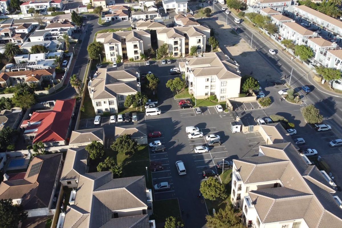 Aerial view of the apartment complex showing the building layout, parking facilities, and surrounding neighborhood infrastructure.