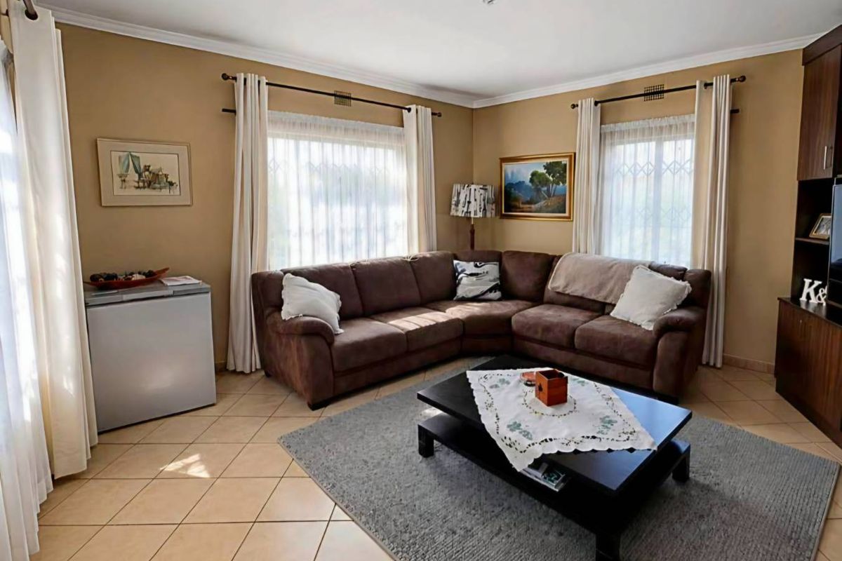 A comfortable living room featuring tiled flooring, neutral wall tones, and built-in cabinetry, offering a functional and well-maintained space for relaxation.