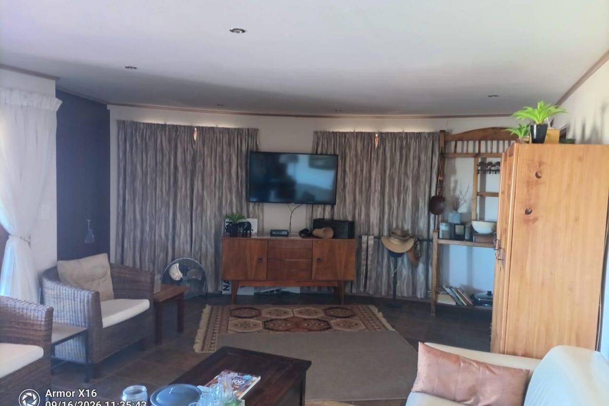 A comfortable living room featuring tiled flooring and recessed downlighting, providing a functional space for relaxation.