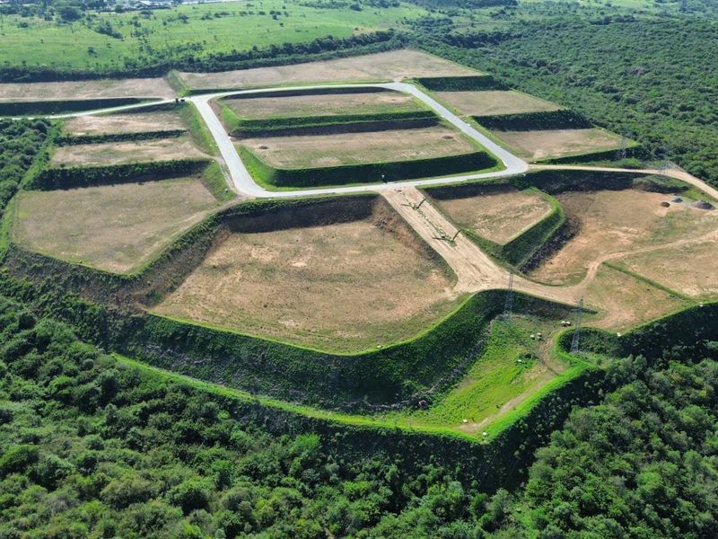 Aerial view of a developed industrial land site featuring terraced platforms and paved access roads surrounded by natural vegetation.