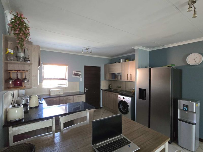 A functional kitchen featuring granite countertops, ample built-in cabinetry, and a tiled backsplash, providing a practical workspace with integrated appliance connections.