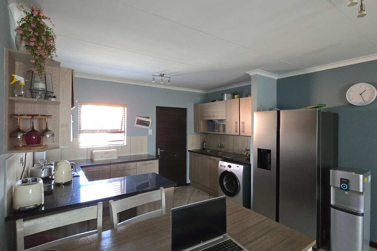 A functional kitchen featuring granite countertops, ample built-in cabinetry, and a tiled backsplash, providing a practical workspace with integrated appliance connections.
