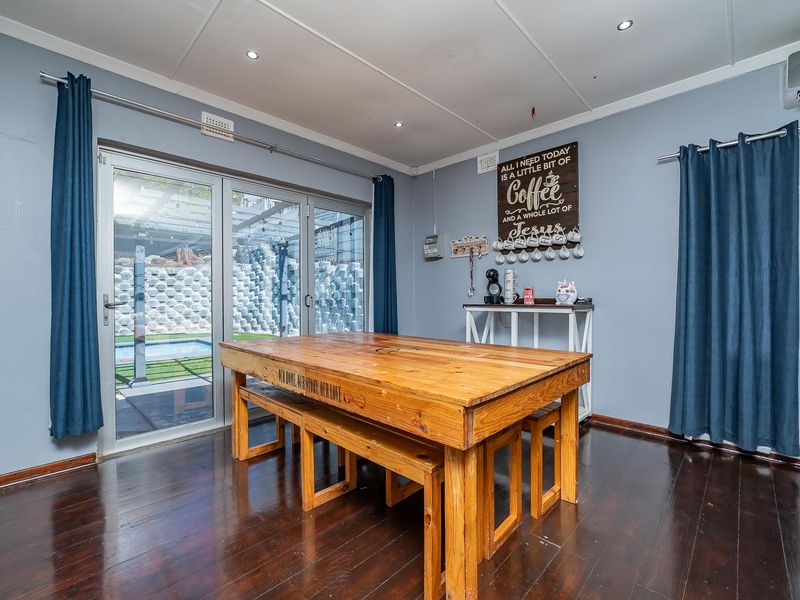 Dining room featuring hardwood flooring, recessed downlights, and sliding glass doors providing direct access to the outdoor pool area.