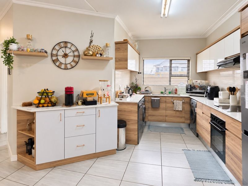 Modern kitchen featuring wood-grain and white cabinetry, tiled flooring, built-in oven, extractor fan, and ample counter space with floating shelving.