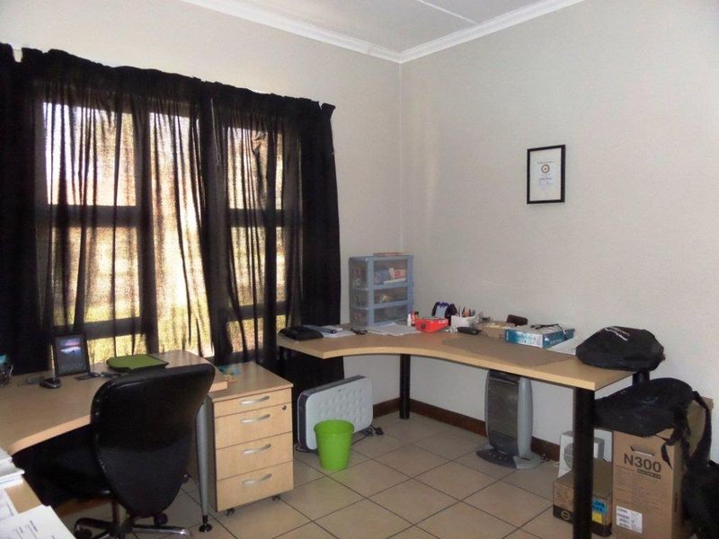 A functional home office space featuring tiled flooring and neutral wall finishes, suitable for a dedicated workspace or study area.