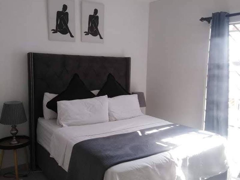 A well-maintained bedroom featuring neutral tiled flooring and a central ceiling light fixture, offering a clean and functional living space.