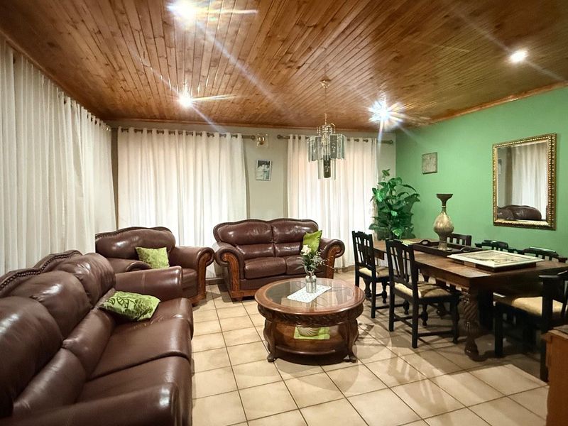 Open plan living and dining area featuring ceramic floor tiles, a timber tongue and groove ceiling, and recessed lighting.