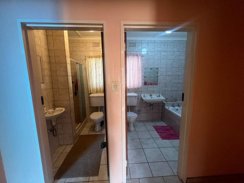 Two adjacent bathrooms featuring tiled finishes, a shower enclosure, a bathtub, and standard sanitary ware.