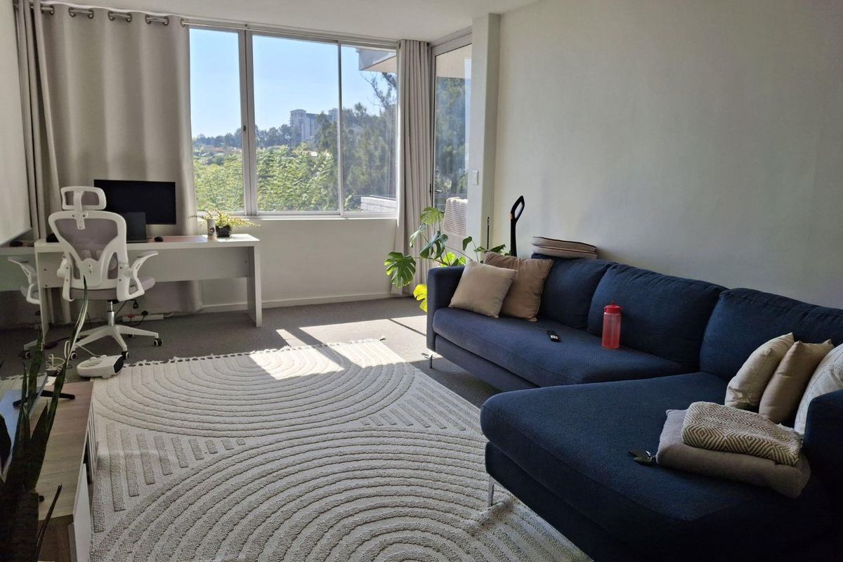 A bright and spacious living room featuring large windows that provide ample natural light and pleasant views.
