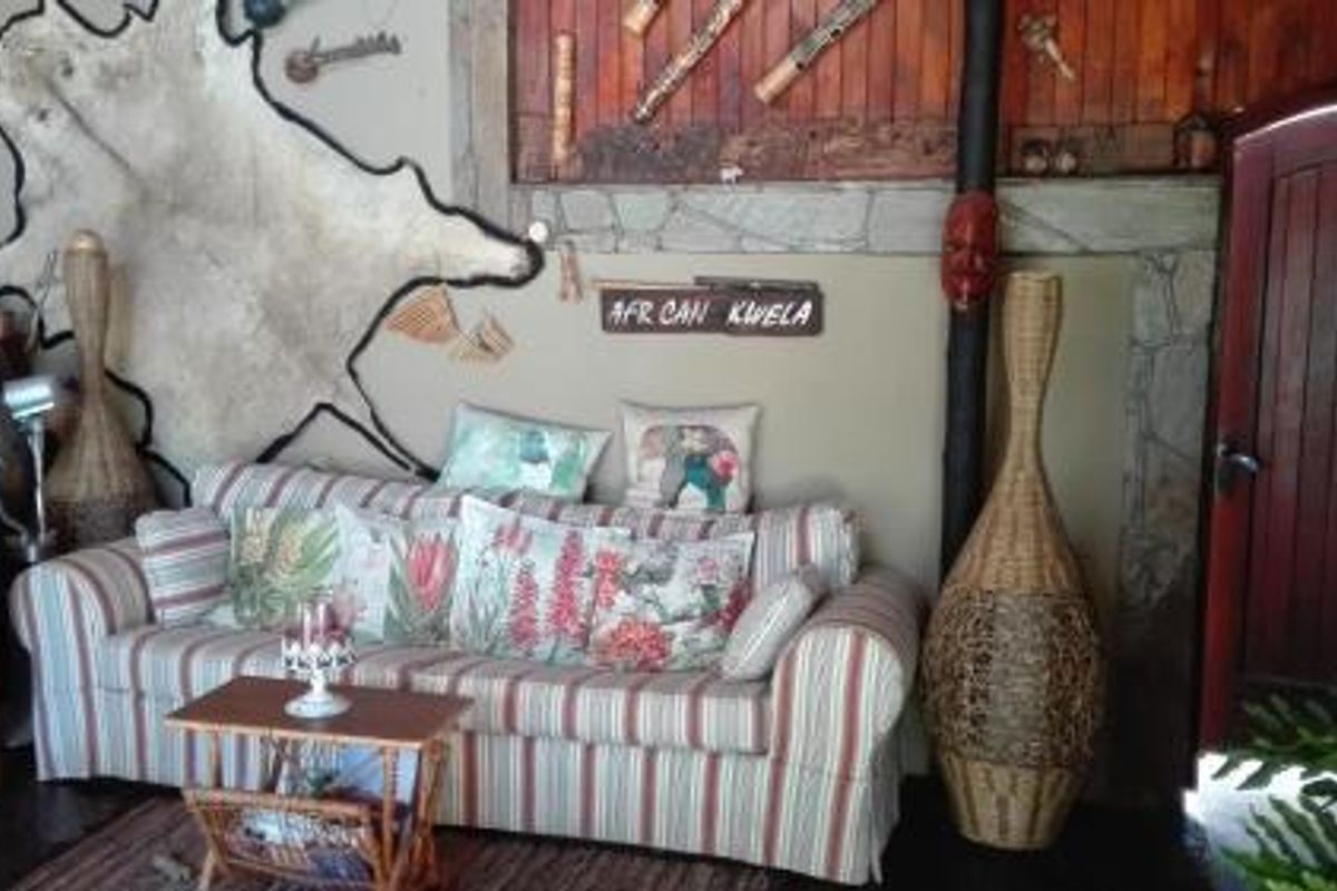 A living room area featuring rustic stone wall accents, wood paneling, and a dark wooden door, creating a warm, traditional atmosphere.