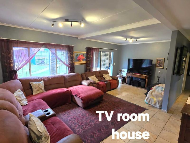 Spacious living room featuring tiled flooring, large sliding glass doors providing natural light, and modern recessed ceiling lighting.