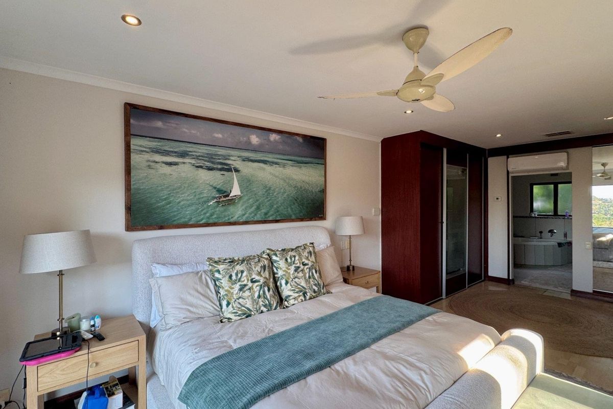 Spacious bedroom featuring a ceiling fan, recessed lighting, built-in wardrobe, and direct access to an en-suite bathroom.