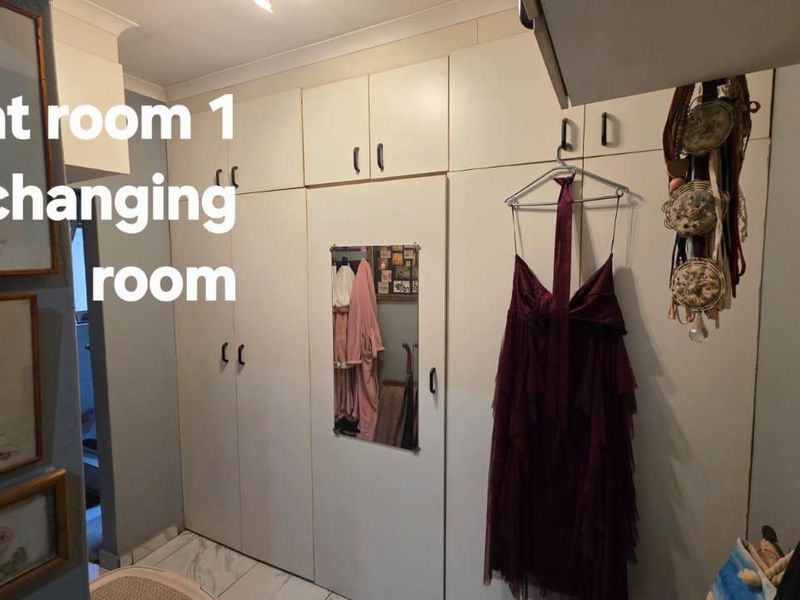 Bedroom featuring extensive floor-to-ceiling built-in cabinetry and tiled flooring, providing ample storage space.