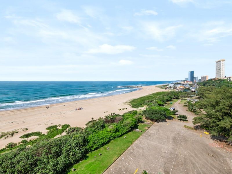 Elevated coastal view overlooking the sandy beach, ocean, and surrounding landscape.
