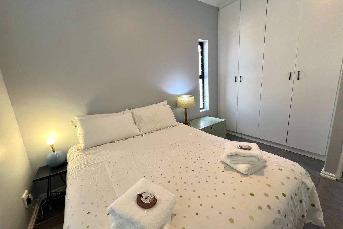 A well-maintained bedroom featuring built-in floor-to-ceiling wardrobes and neutral wall finishes, providing a clean and functional living space.