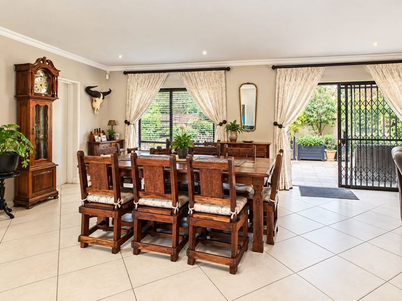 Spacious dining room featuring neutral tiled flooring, recessed lighting, and direct access to an outdoor patio area through a secure sliding glass door.