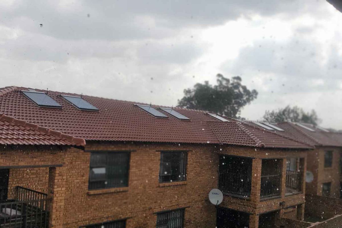 Exterior view of a brick apartment complex featuring tiled roofing with integrated solar water heating panels.