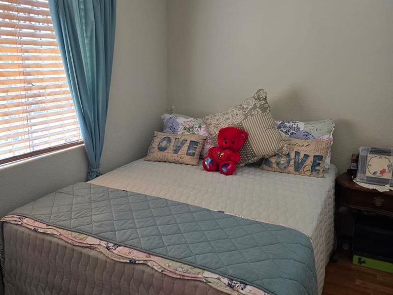 A standard bedroom featuring laminate flooring and venetian blinds, providing a functional and neutral space ready for personalization.