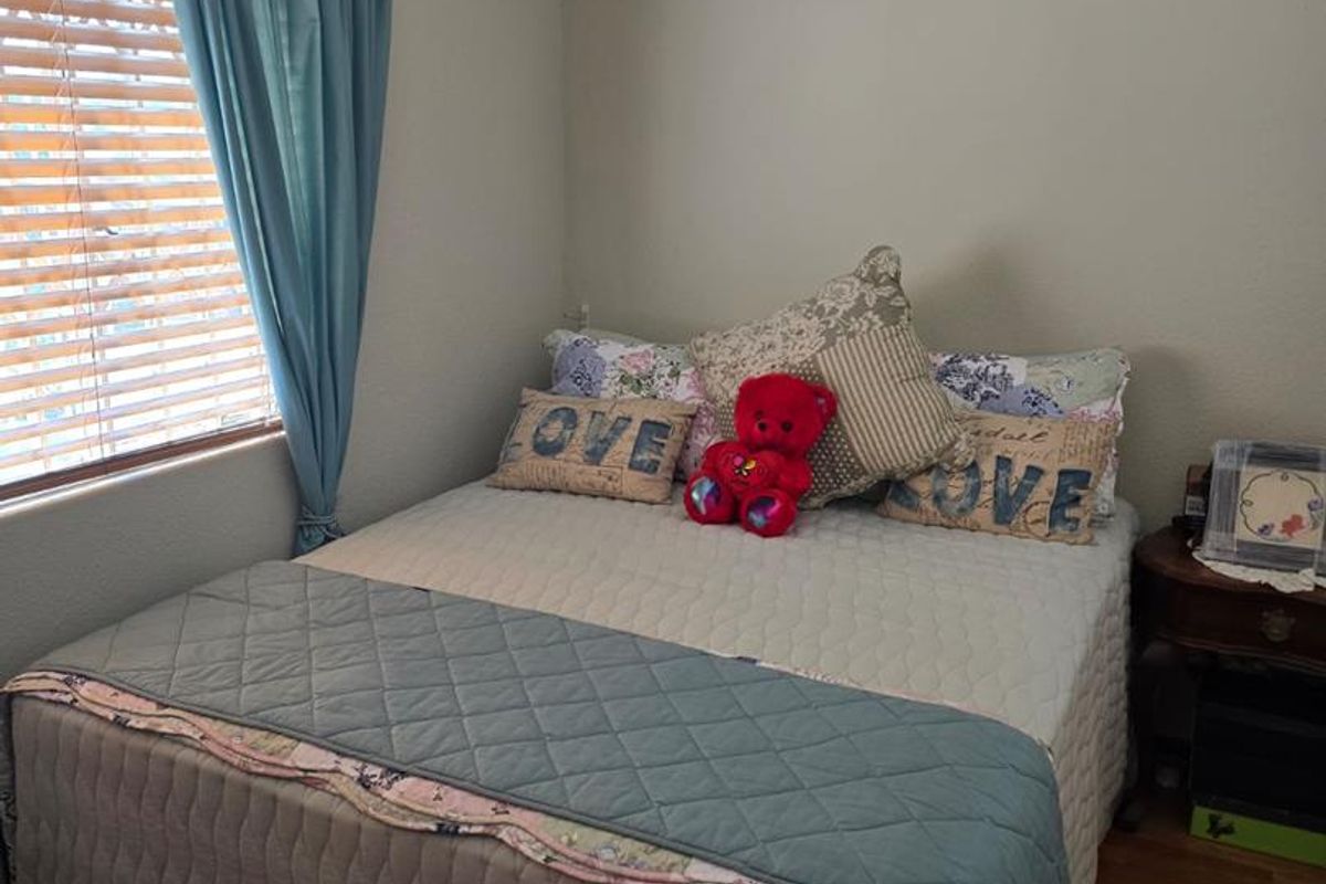 A standard bedroom featuring laminate flooring and venetian blinds, providing a functional and neutral space ready for personalization.