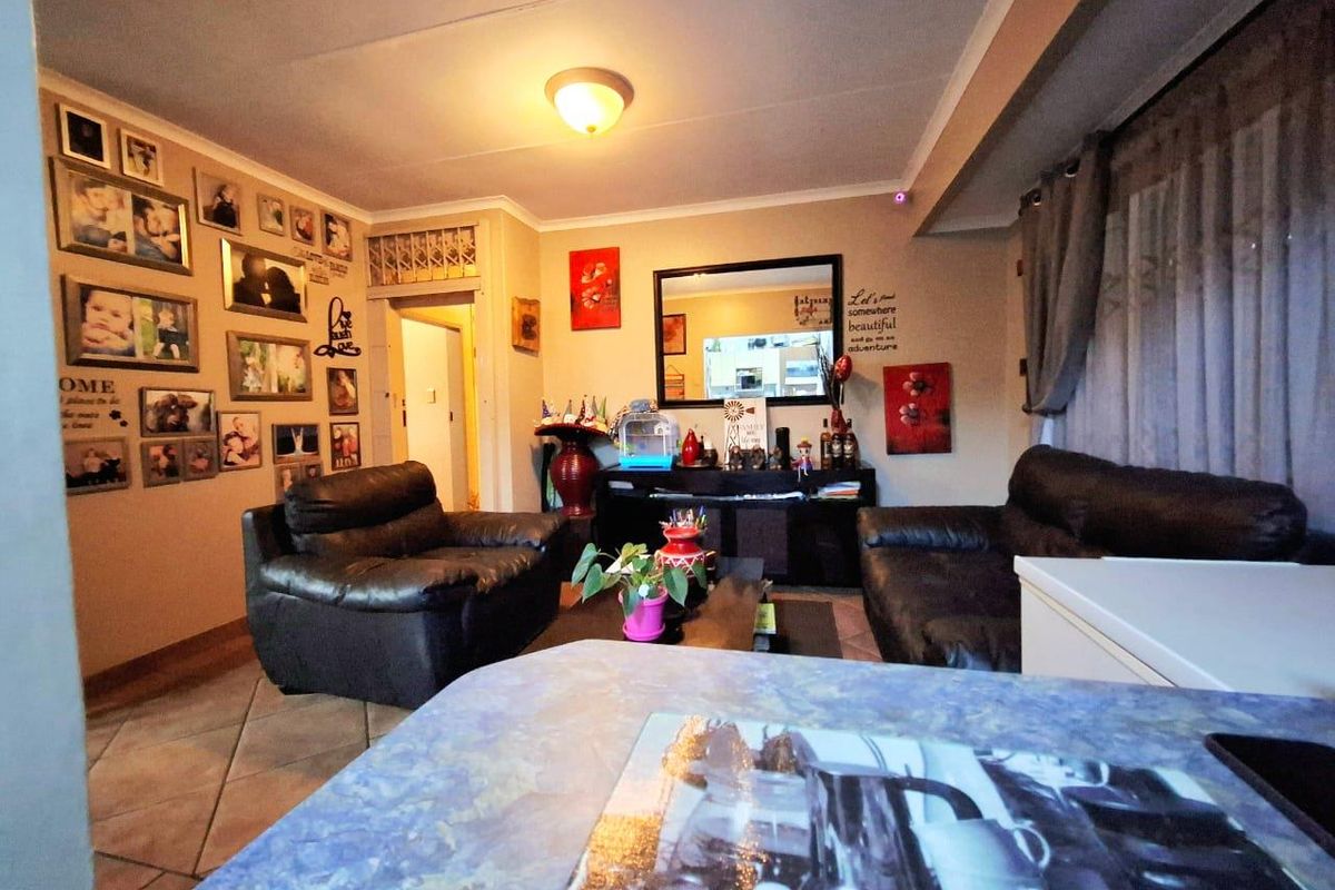 A comfortable living room area featuring tiled flooring and neutral wall finishes, providing a functional space for relaxation.