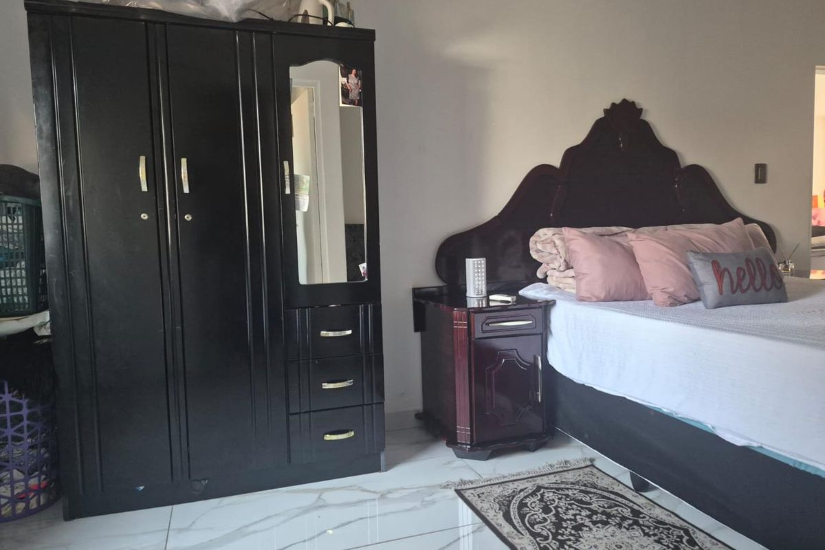 A bedroom featuring white marble-look tiled flooring and neutral wall finishes.