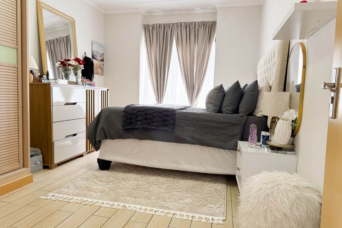 A well-maintained bedroom featuring light-toned tiled flooring, a built-in wardrobe, and coved ceiling details, offering a clean and functional living space.