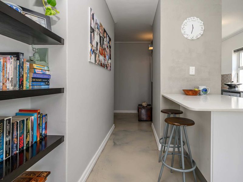Open plan living area featuring polished concrete floors, built-in shelving, and a breakfast bar counter.