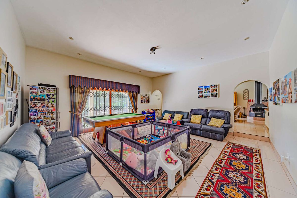 Spacious living room featuring tiled flooring, recessed lighting, and an arched entryway leading to an adjacent area with a fireplace.