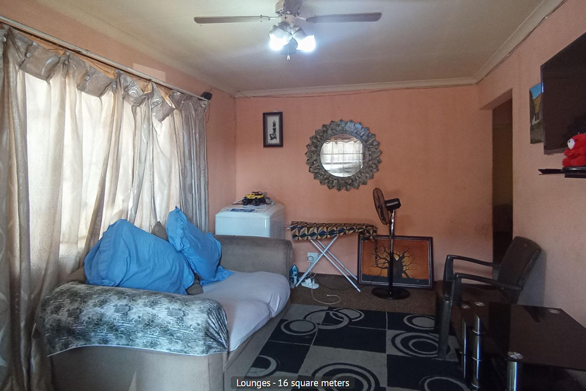 A living room featuring a ceiling fan, large window with curtains, and wall-mounted television space.