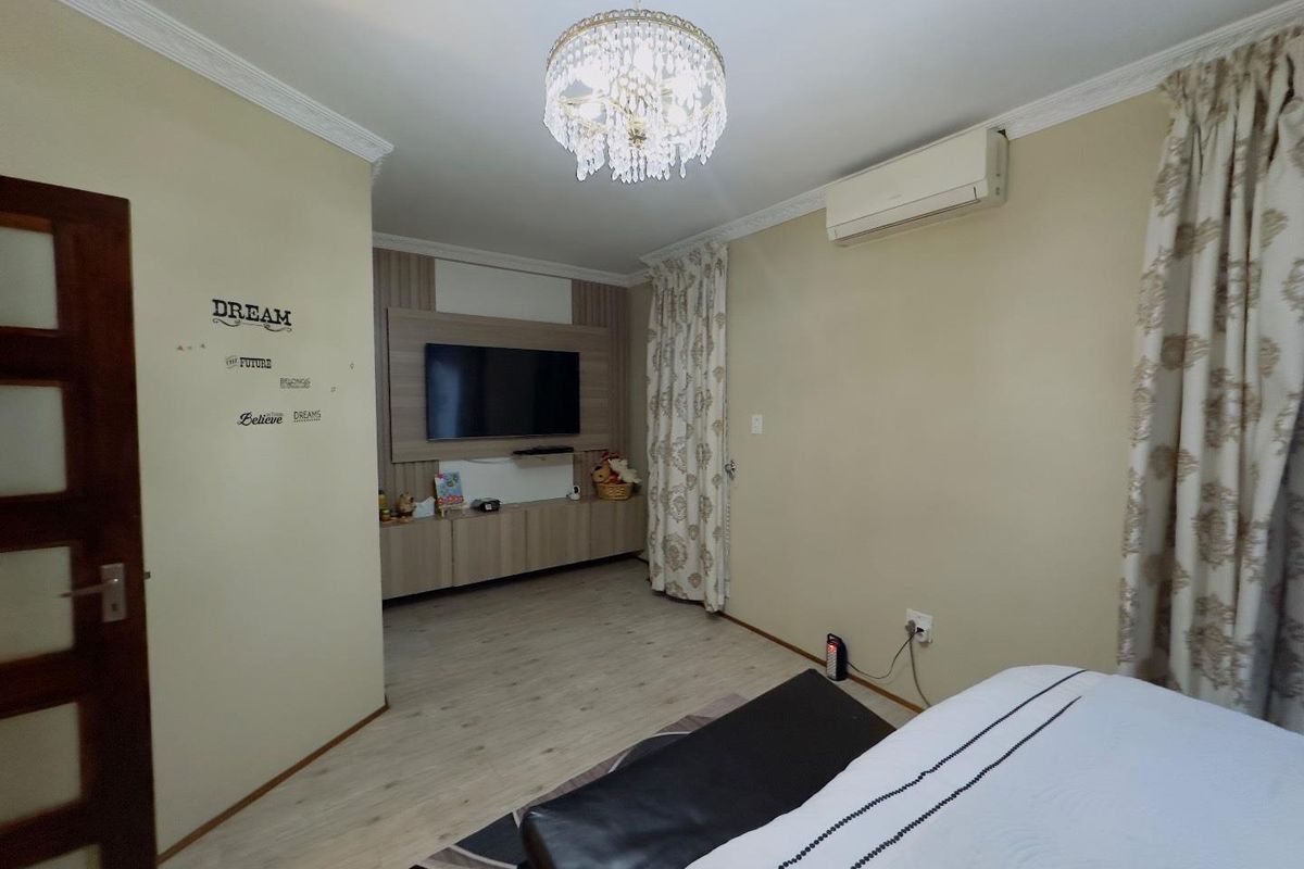 A bedroom featuring a built-in media unit, crown molding, and a wall-mounted air conditioning unit.