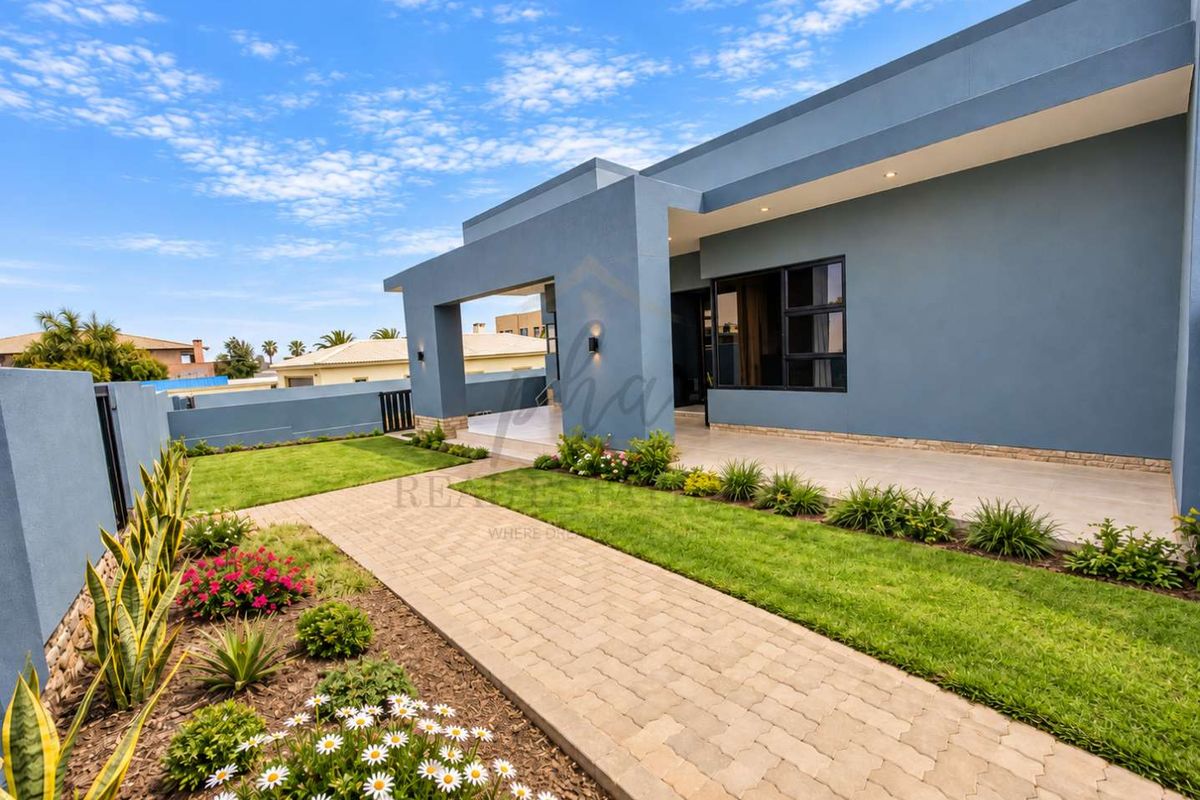 A well-maintained rear exterior featuring a paved walkway, landscaped garden, and a covered patio area with modern finishes.