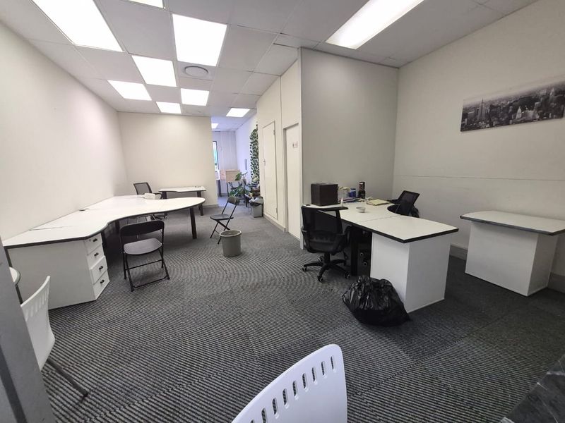A functional office space featuring suspended ceilings with recessed lighting and durable carpet tiles, suitable for a professional work environment.