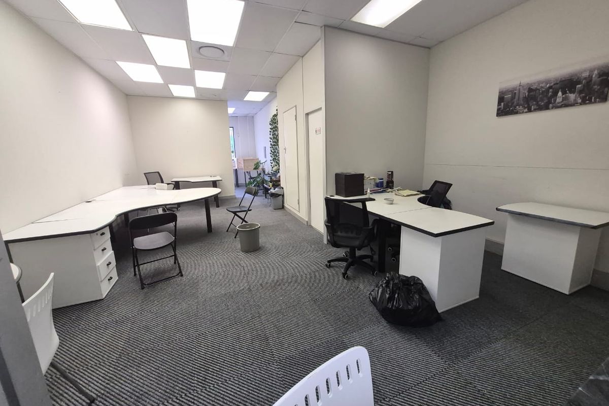 A functional office space featuring suspended ceilings with recessed lighting and durable carpet tiles, suitable for a professional work environment.