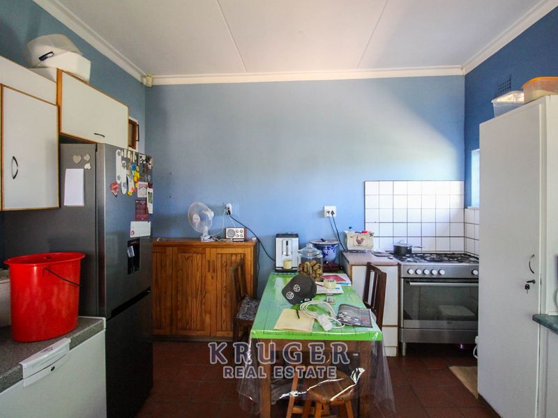A functional kitchen featuring built-in cabinetry, a gas stove with oven, and tiled splashbacks, offering a practical layout for daily cooking and meal preparation.
