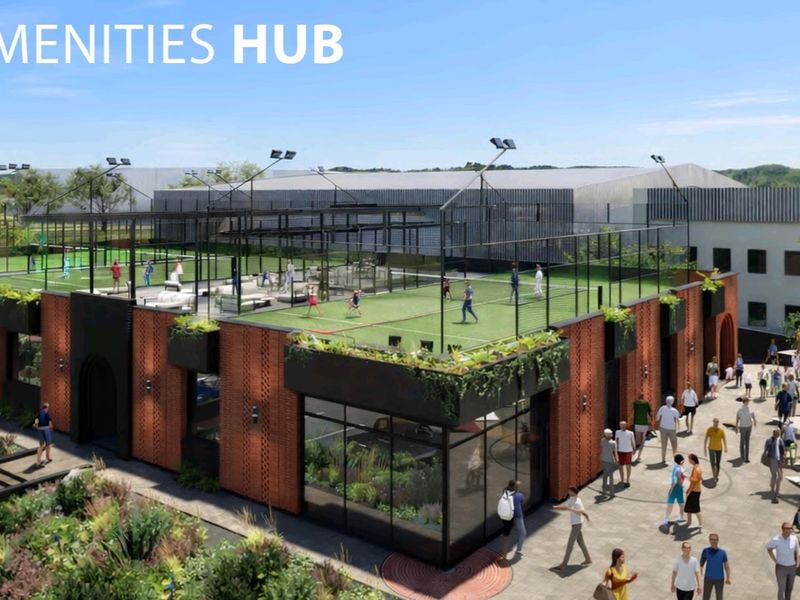 An aerial view of a modern industrial amenities hub featuring a rooftop sports facility and landscaped outdoor communal areas.