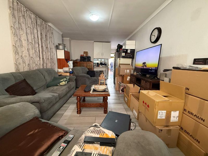 Open plan living area featuring tiled flooring and a connected kitchen space, providing a functional layout for daily living.