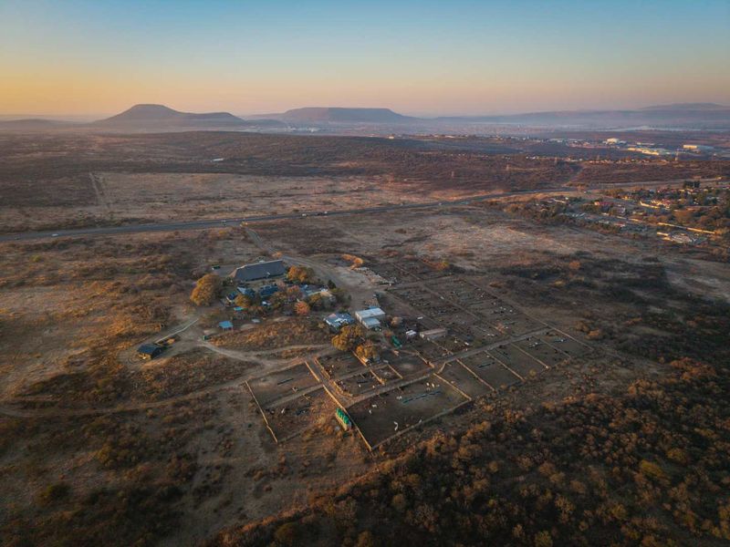 Aerial view of the guest house property featuring extensive grounds, fenced enclosures, and surrounding rural landscape.